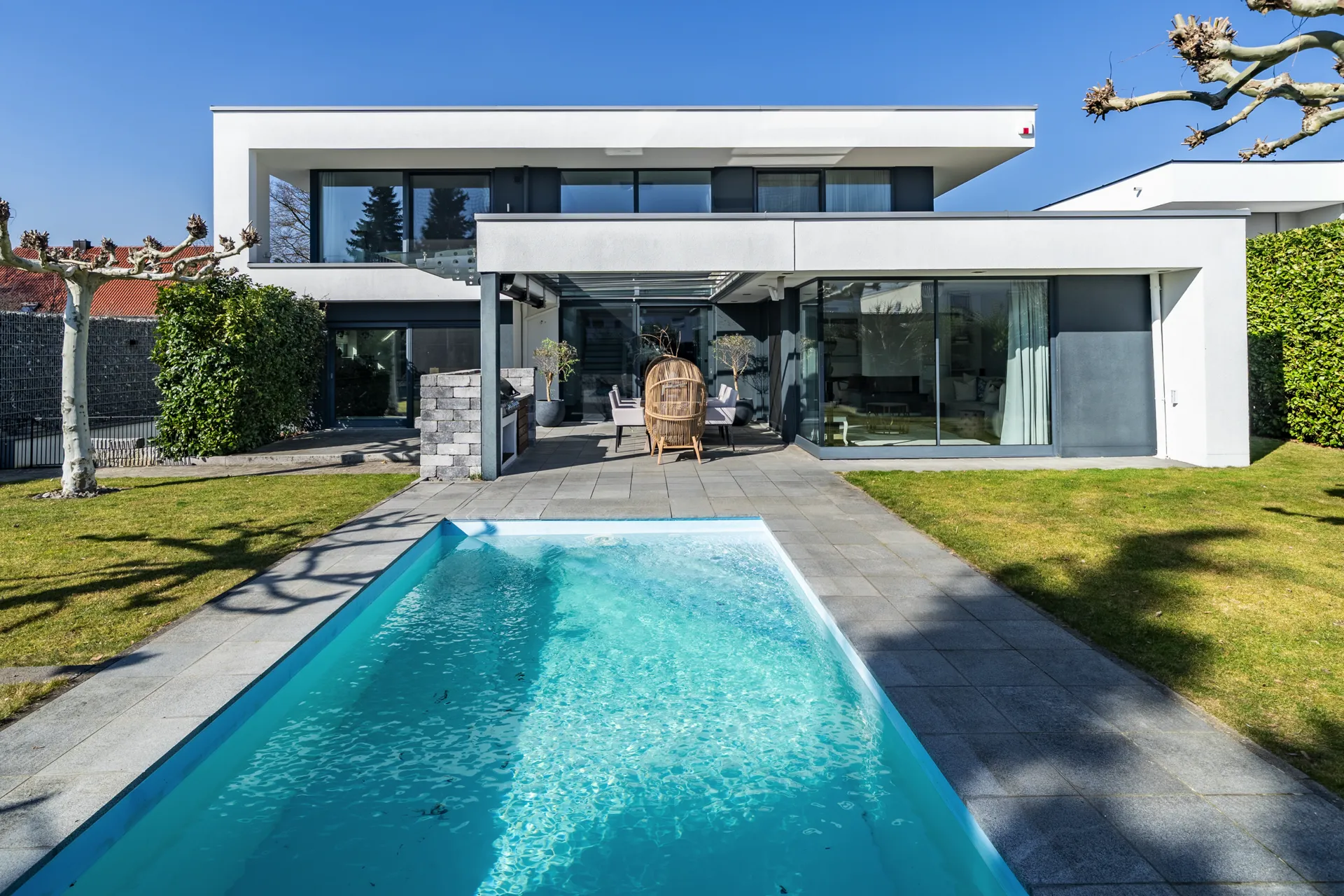 Modernes Architektenhaus in Schwabmünchen mit zwei übereinanderliegenden Kuben und Pool im Vordergrund