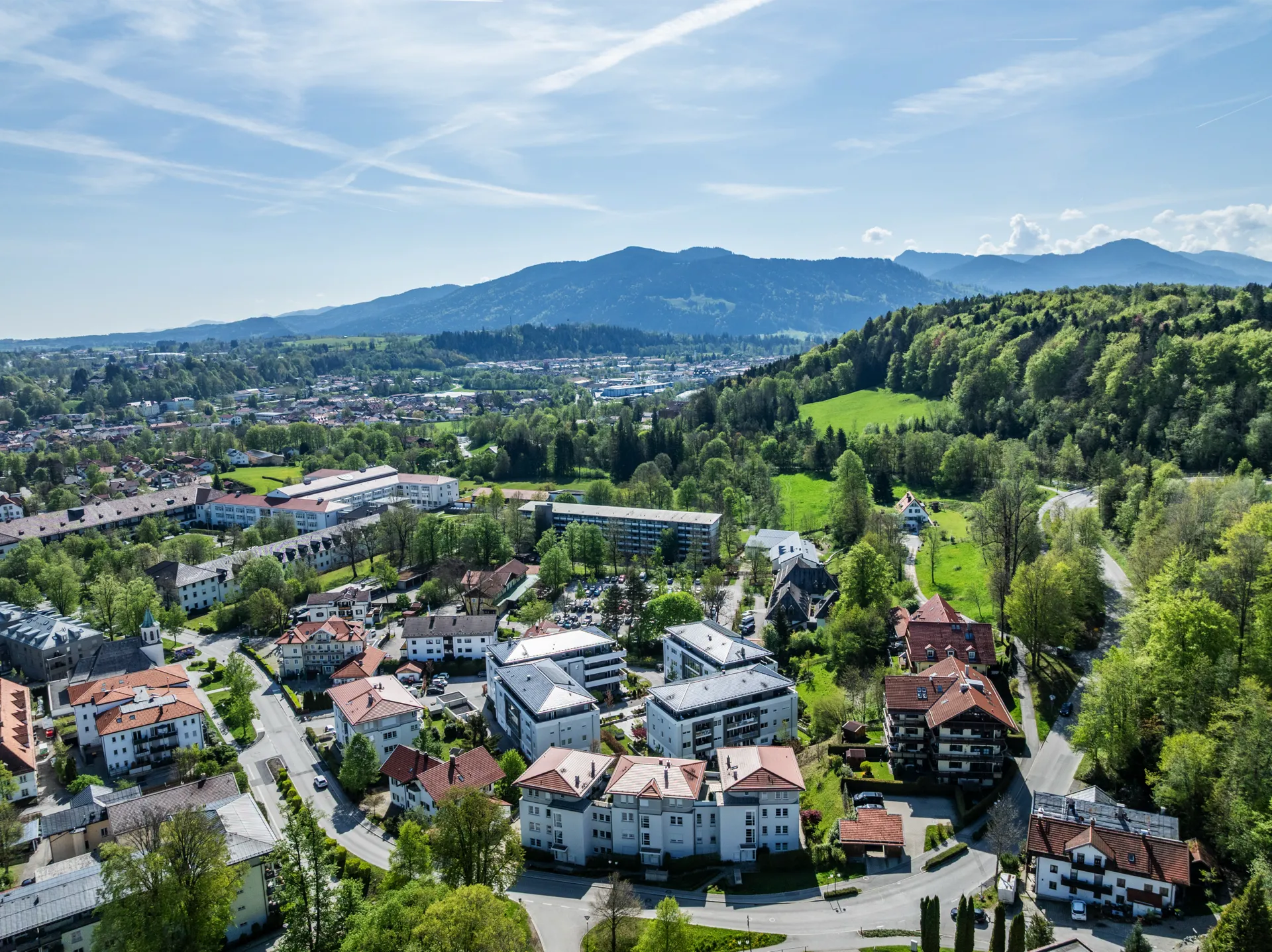 Drohnenaufnahme Bad Tölz mit Blick auf Wohngebiete, Kureinrichtungen und Alpenpanorama im Hintergrund